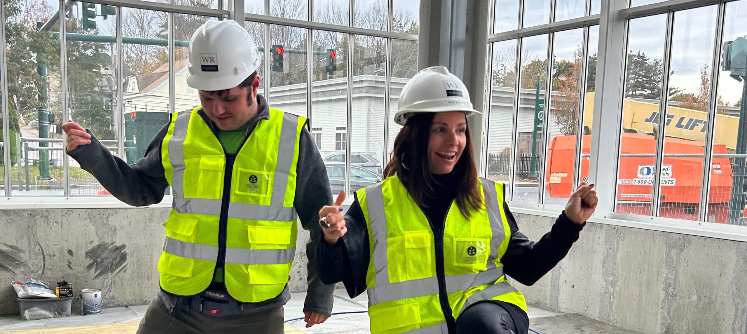 2 Vertical Harvest employees dancing in a new vertical farm under construction